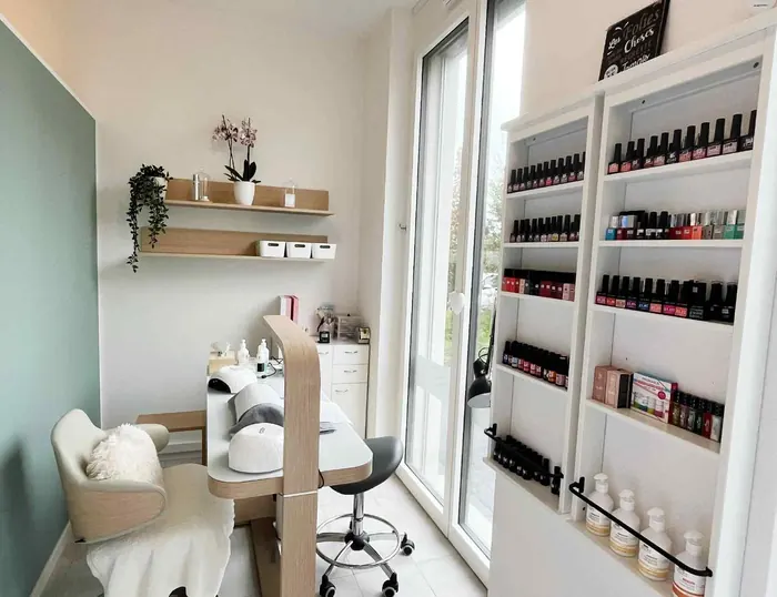 L’onglerie : table de manucure en bois clair, orchidée et étagère de vernis